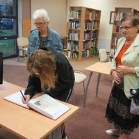 Uczestnicy spotkania wpisują się do kroniki bibliotecznej.