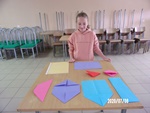 Prowadząca pokaz origami dziewczynka przygotowuje się do zajęć.