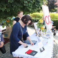 Pani bibliotekarka przybija pieczątkę na pamiątkowej kartce.