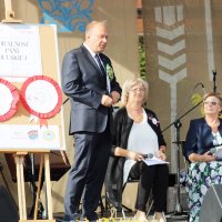 Dyrektor MDK Artur Jakubowski zapowiada Narodowe Czytanie, na scenie siedzą już czytające osoby.