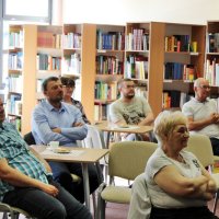 Zdjęcie części publiczności widać osiem osób obecnych na spotkaniu.