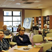 Zdjęcie z połowy sali pokazujące tył zgromadzonej widowni, widać siedem kobiet i jednego mężczyznę.