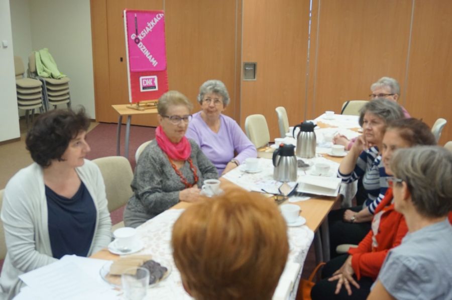 7 uczestniczek spotkanie DKK podczas rozmowy, siedzą przy stole na którym widać termosy z kawą i herbatą