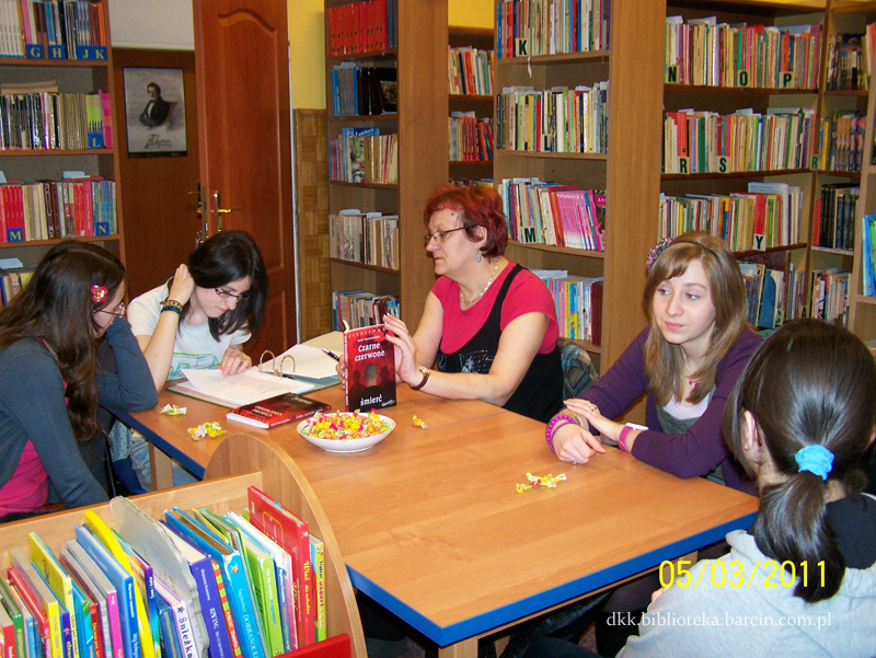 Uczestniczki i prowadząca siedzą przy stole, rozmawiają o przeczytanej książce