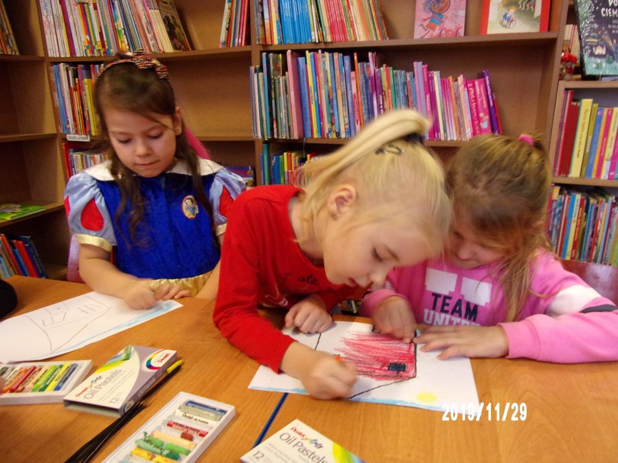 Dziewczynki kolorują kredkami, wykonane wcześniej szkice.