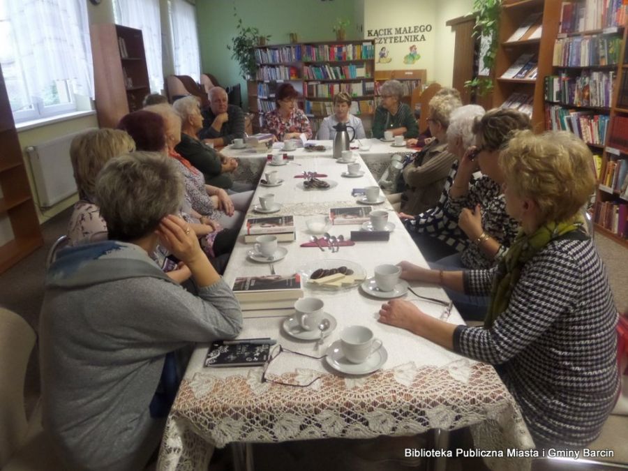 Wszyscy uczestnicy spotkania siedzą przy stołach ustawionych w literę T, patrzą w stronę prowadzącej spotkanie