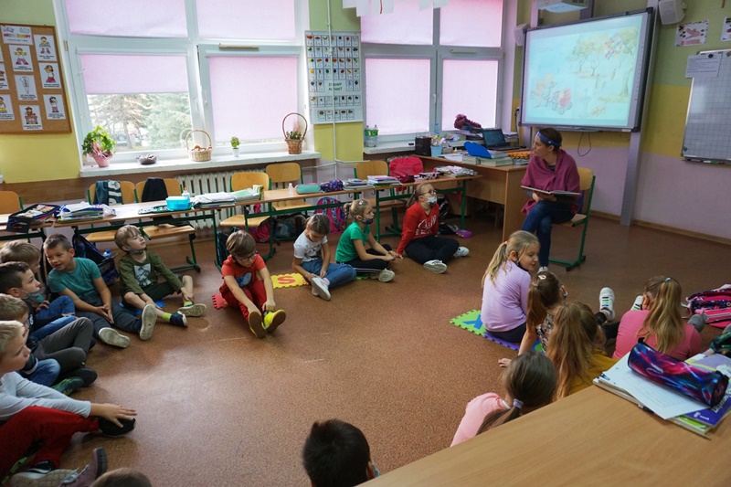 Prowadząca spotkanie czyta dzieciom fragment książki.