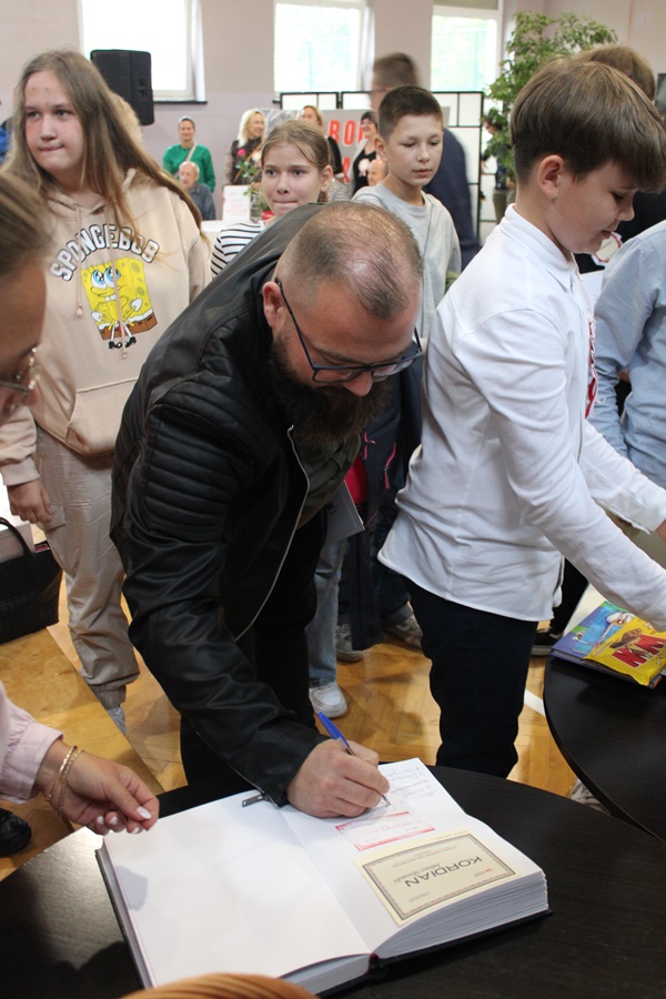 Dyrektor Miejskiego Domu Kultury w Barcinie składa podpis w pamiątkowej kronice