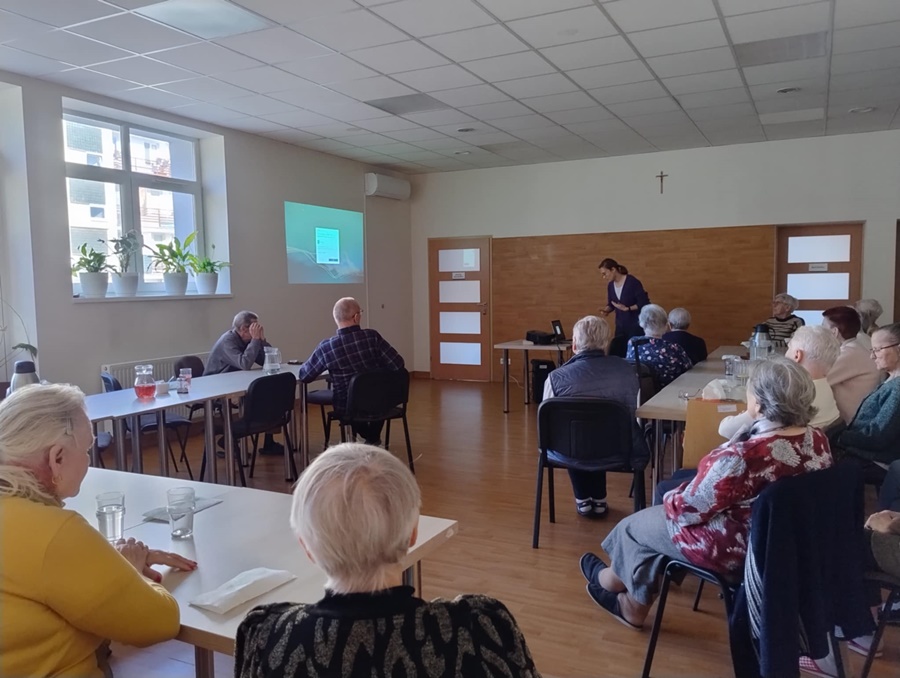 Zebrani uczestnicy i stojąca z przodu prowadząca